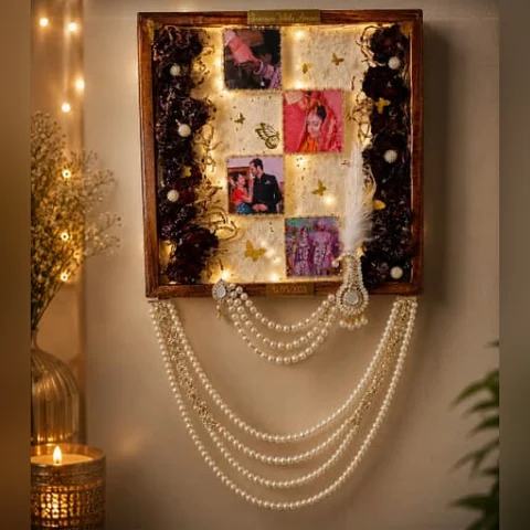 Varmala preservation frame with four wedding photos, fairy lights and a pearl hanging by Jhilmil Decor
